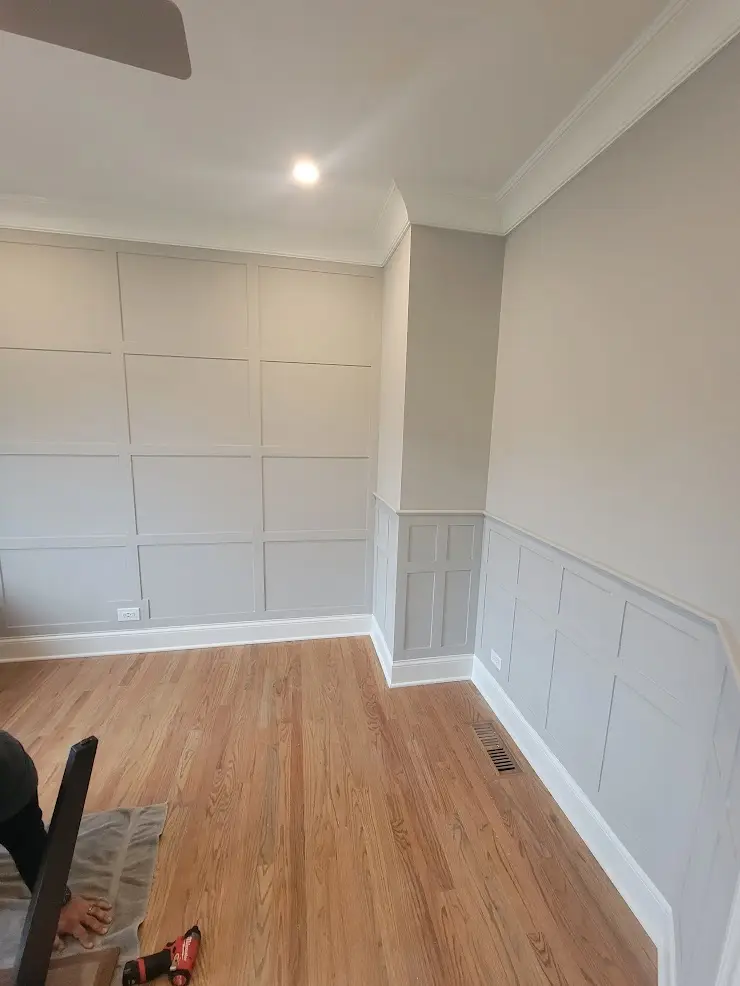 Modern board and batten wall design with professional paint finish in light gray, featuring custom grid pattern and crisp white trim work in Chicago area home