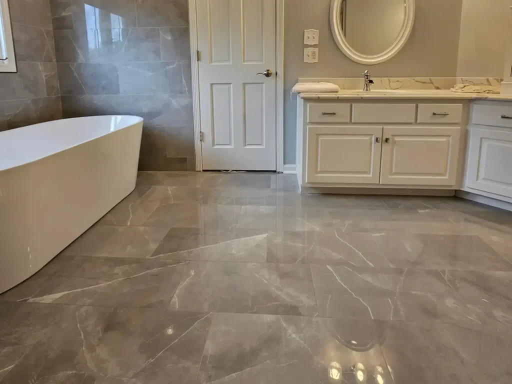 Modern bathroom renovation featuring large-format gray tile walls, custom white cabinetry, and professional Schluter waterproofing installation in Chicago area