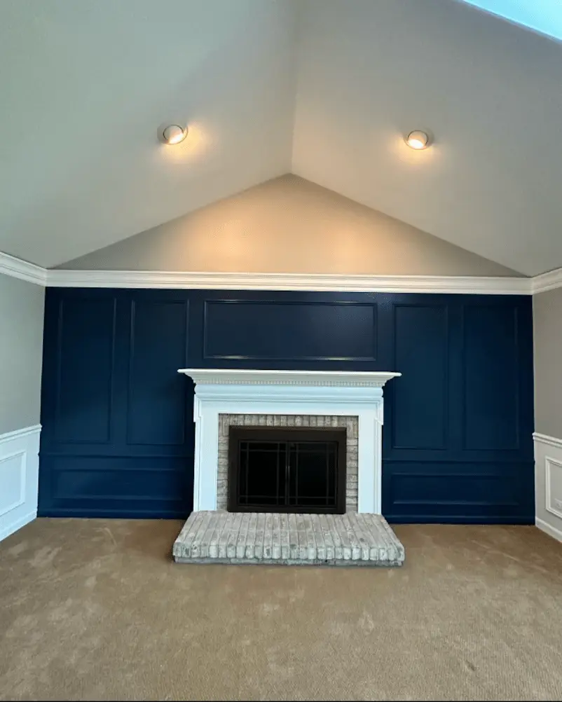 Stunning fireplace accent wall transformation in Bolingbrook featuring deep navy blue paint, pristine white trim work, and vaulted ceiling finishing by ACE 123 Contractors